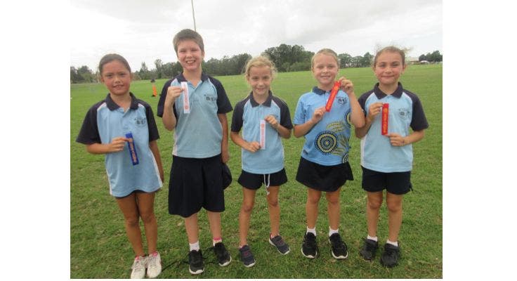 photo of children with winner ribbons at cross country